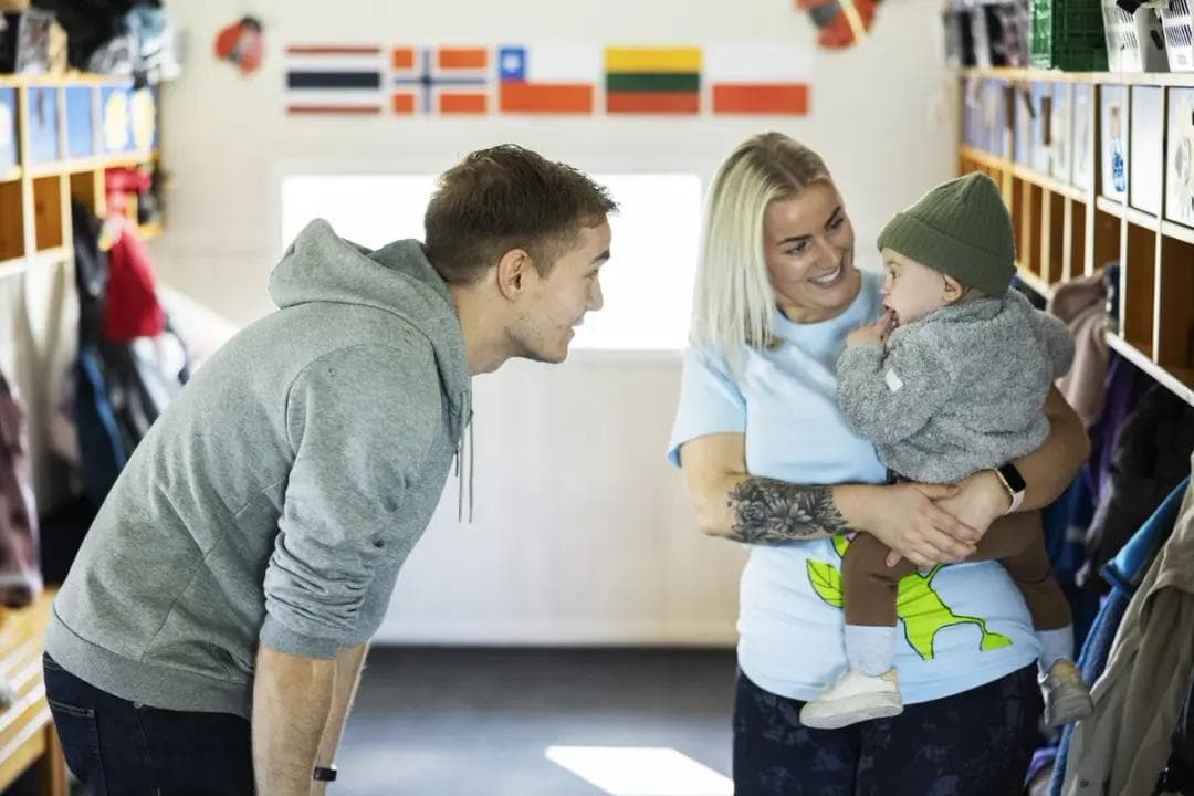 a man and a woman are holding a baby in a room .
